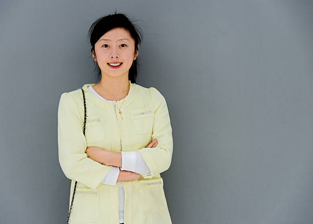 istock Young woman smiling against gray wall 585313800