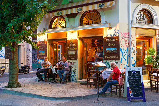 Athens, Greece - August 02, 2016: Coffee shop in Psirri neighborhood in Heroes' square, Athens. There are musicians playing live Greek music.