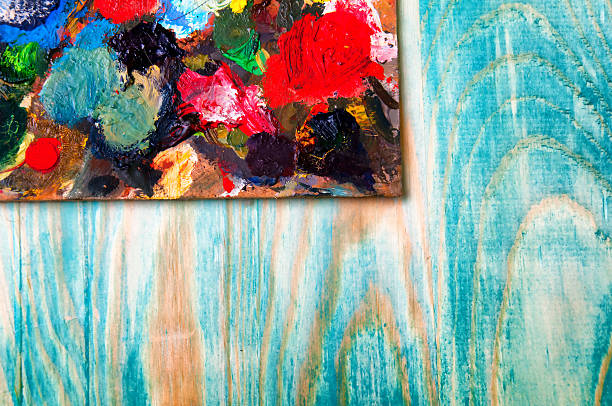 istock Painting palette on colored wooden background 585318684
