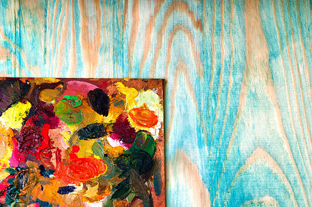 istock Painting palette on colored wooden background 585319056