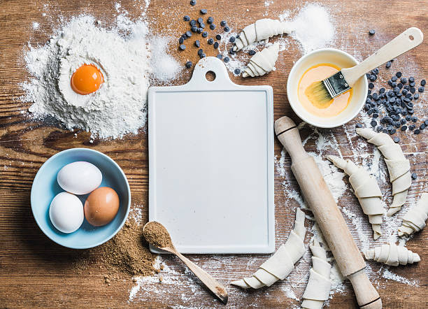 istock Baking ingredients for cooking croissants with white board in center 585320164