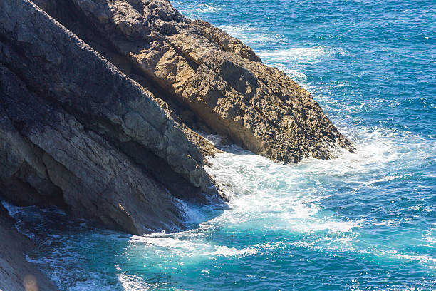 istock ocean waves crashing on the rocks with white foam 585320418