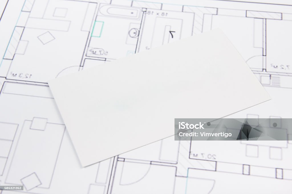 Architectural project, blueprints, key with house figure and blank business Architectural project, blueprints, silver key with house figure and blank business card on wooden background. Real Estate Concept. Top view Accessibility Stock Photo