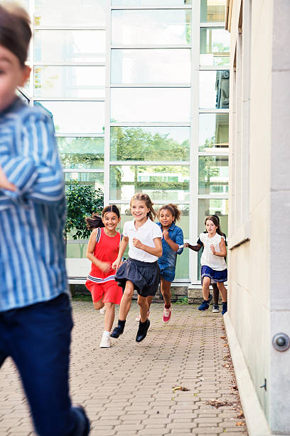istock Elementary age kids running in school playground outdoors. 585325374