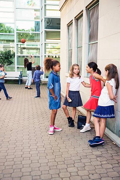 istock Elementary age kids taking a break in school playground outdoors. 585325654