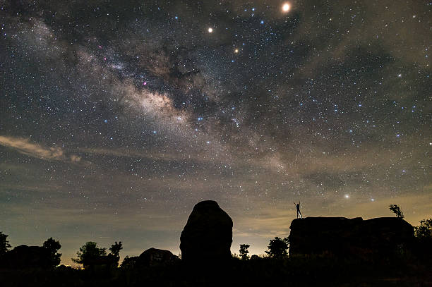 istock The man hands up on  the rock and watching Milkyway 585326402