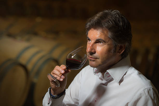 istock Man Smelling Wine in glass, Vintner drinking red wine 585327108