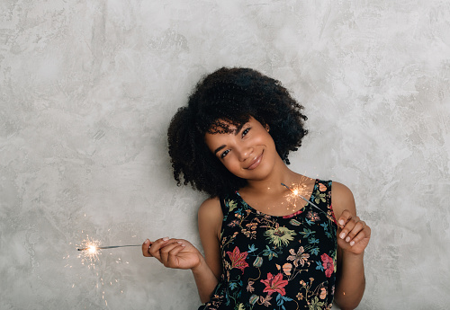 African American young woman teenage girl playing with sparklers