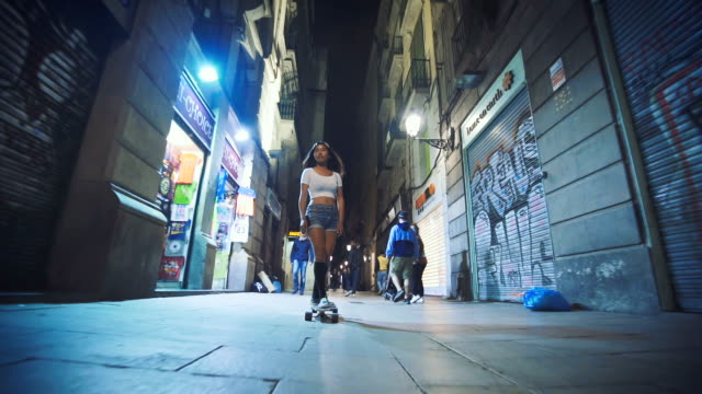 Woman skateboarding on street at night