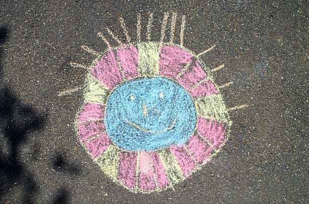 istock Colorful sun drawn with chalk on asphalt 585482430