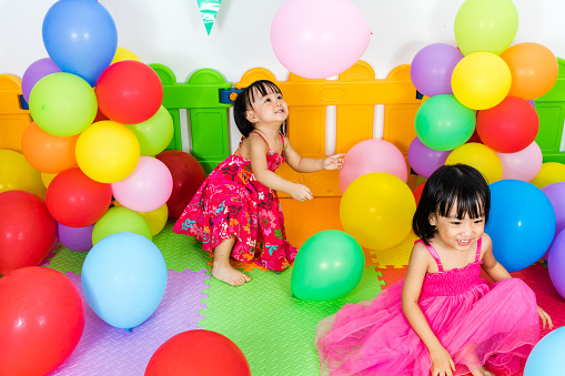 Asian Little Chinese Girls Playing with Colorful Balloons in Indoor Playground