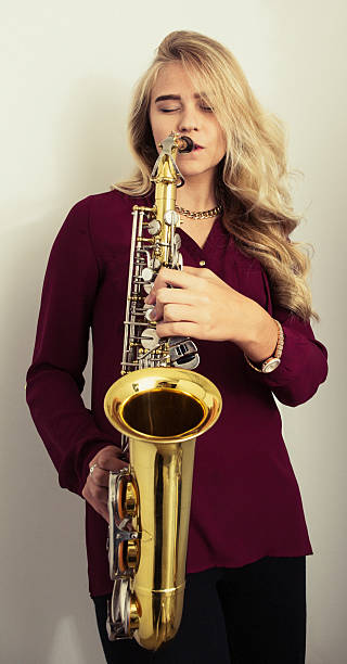 istock Young woman playing saxophone 585485340