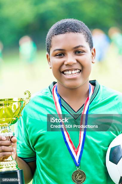 Excited African American Teenage Soccer Player With Championship Trophy Stock Photo - Download Image Now