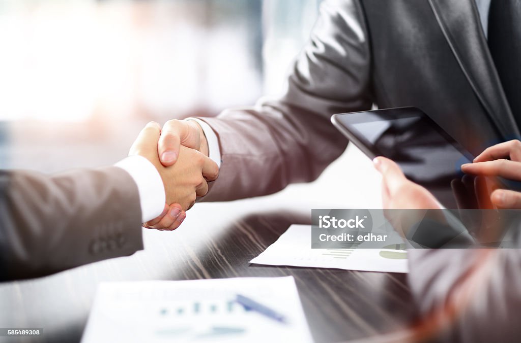 Business partners shaking hands Business partners shaking hands at the table Adult Stock Photo