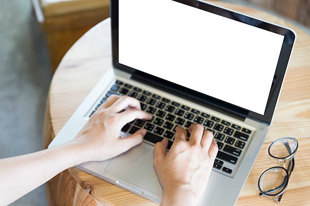 istock woman's hand on computer notebook with eyeglasses on wooden desk 585491648
