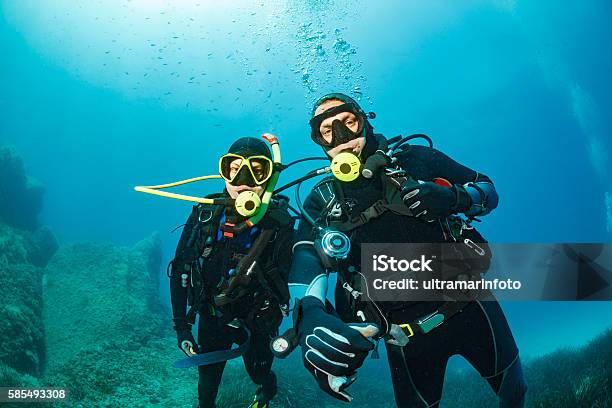 Scuba Diving Underwater Couple Scuba Divers In Blue Stock Photo - Download Image Now