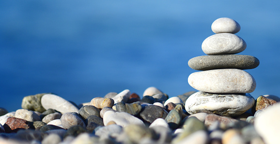 balancing stone tower against blue sea