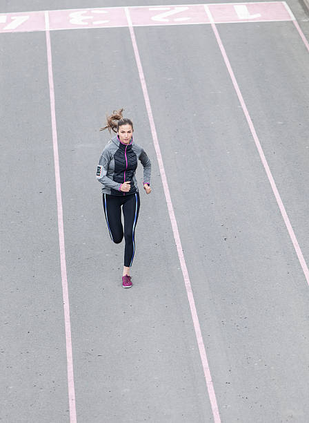 istock Young sportswoman running on sport track 585497874