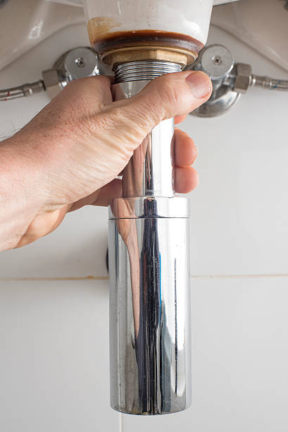 istock Plumber tightens bathroom sink waste pipe 585497878