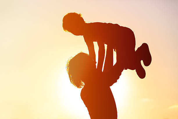 istock father and little son silhouettes play at sunset 585501610