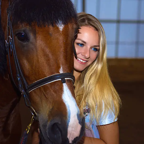 Portrait of beautiful smiling woman with a horse
