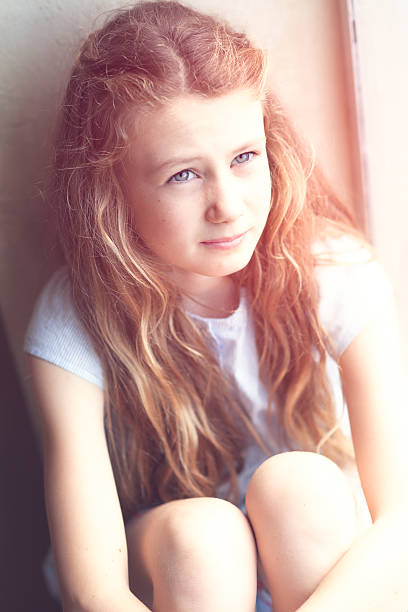 Portrait of a young woman looking at the camera through glass.