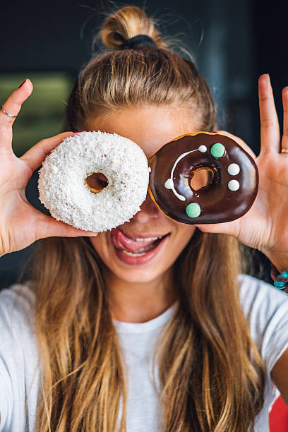 istock Woman have fun with donuts 585502886