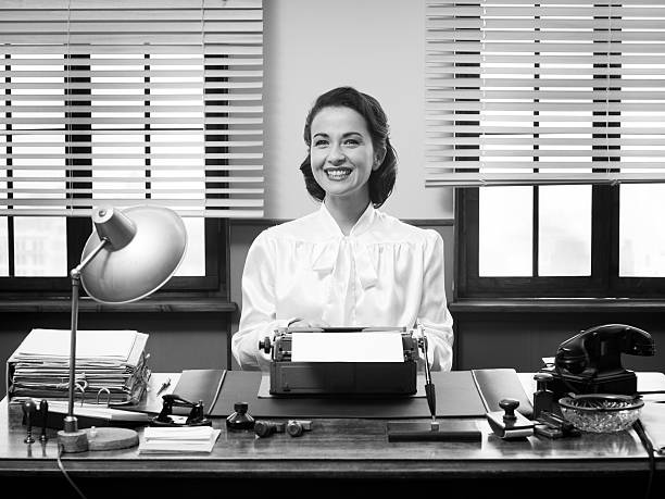 Cheerful vintage secretary Cheerful vintage secretary working at office desk and smiling at camera vintage women stock pictures, royalty-free photos & images