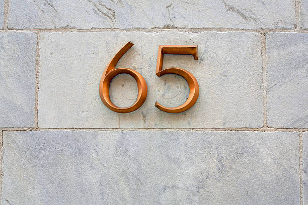 istock Sign of 65 on marble exterior wall 585504632