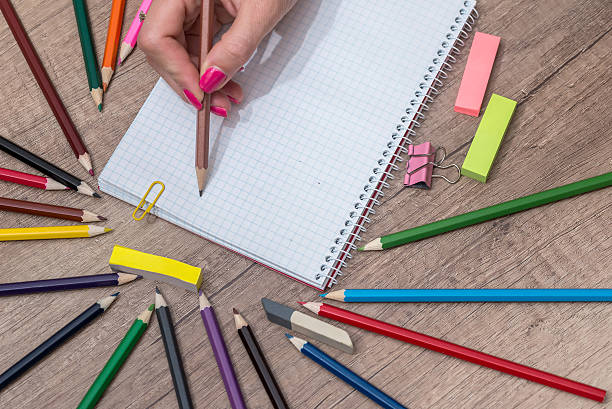 istock Girl drawing empty note with colorful pencils on  wooden table 585505868