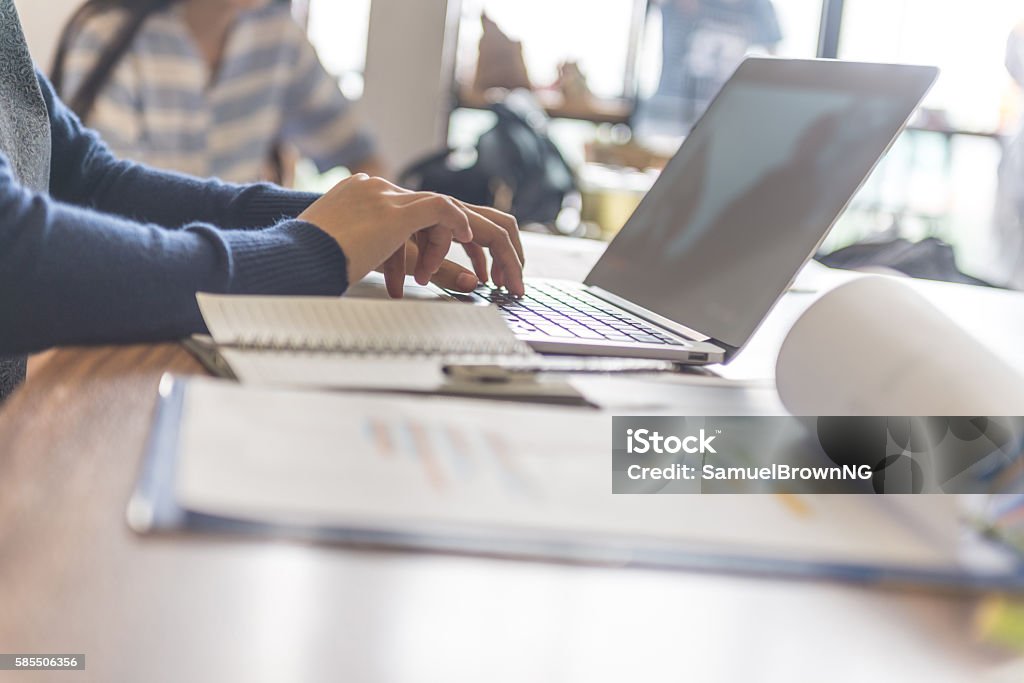 Close-up of businesswoman hand typing on laptop at workplace Filing Documents Stock Photo