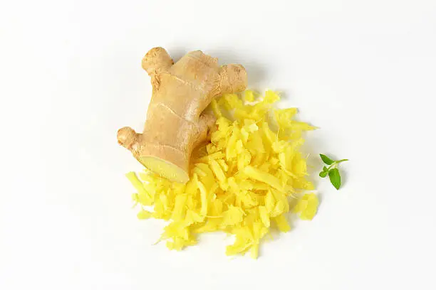 whole and grated fresh ginger on white background