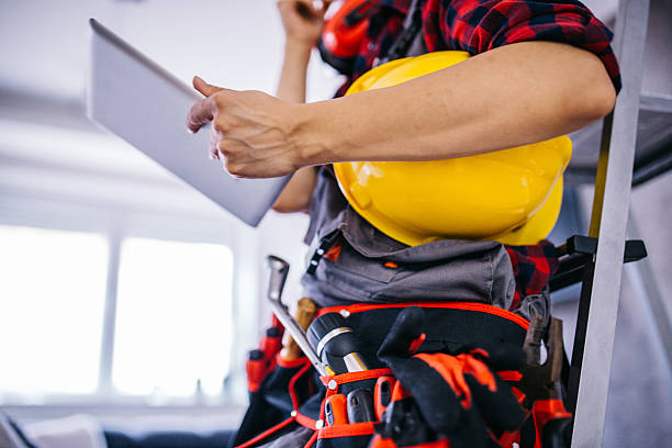 Work planning Female construction worker with tools.Female takes care of the house.Woman handyman.There helmet on his head and a tool belt on.Tablet and search woman wearing tool belt stock pictures, royalty-free photos & images