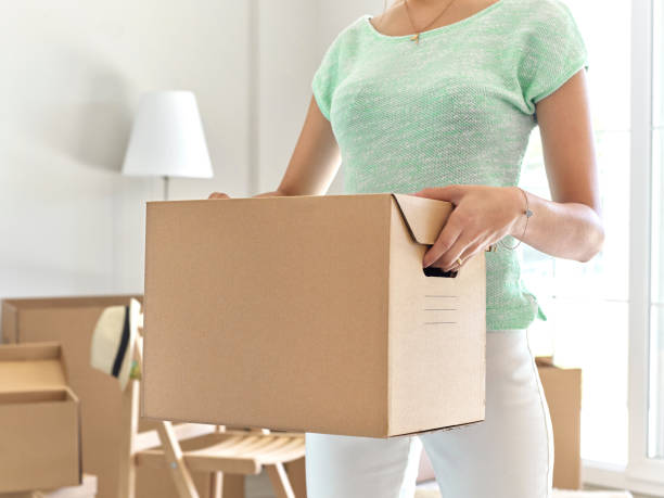 istock Woman carrying cardboard box 585509168