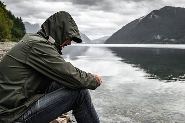 Solitude man pensive on the lake side