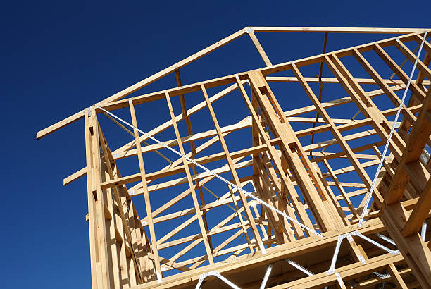 New construction home framing against blue sky