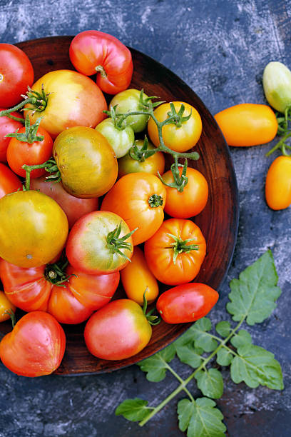 istock tomatoes in a wooden bowl, top view 585512346