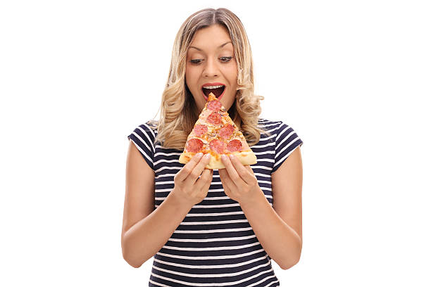 Blond woman eating a slice of pizza isolated on white background