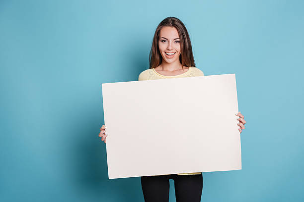 istock Pretty young woman holding empty blank board over blue background 585519392