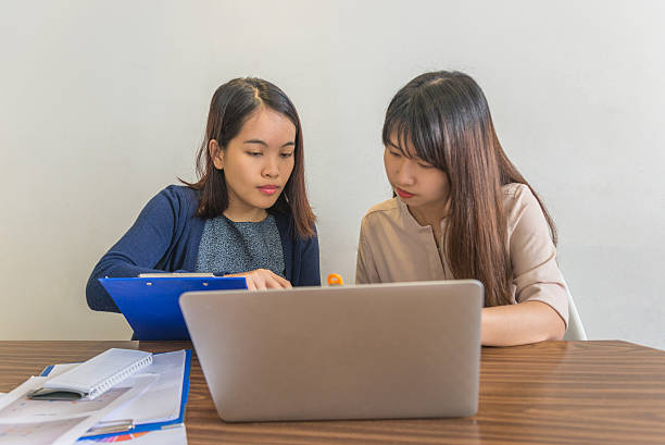istock Office woman discuss with her teammate about sales reports 585519490