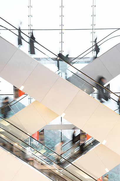 moderne rolltreppe mit verschwommenen menschen - people office architecture stock-fotos und bilder
