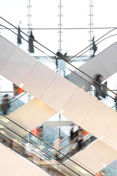 escalera mecánica moderna con personas borrosas - escalator people city blurred motion fotografías e imágenes de stock