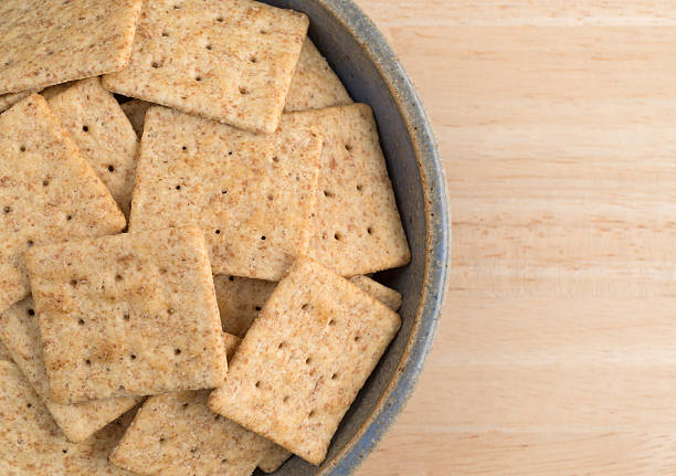 istock Bowl of organic whole wheat crackers on a wood table 585520484