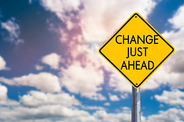 istock Yellow road sign change just ahead on blue cloudy sky 585521348