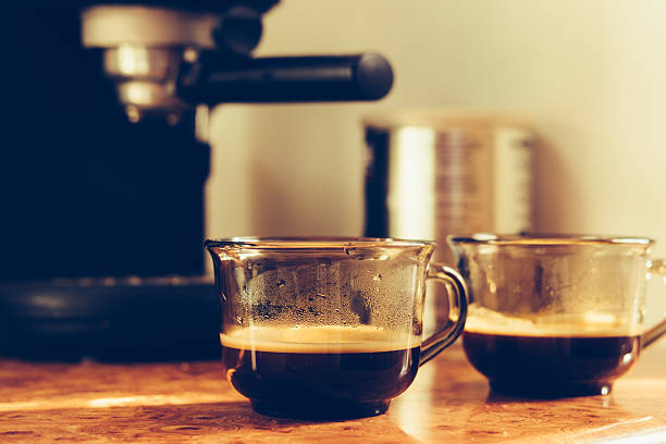 Two cups of coffee on the table near coffee machine