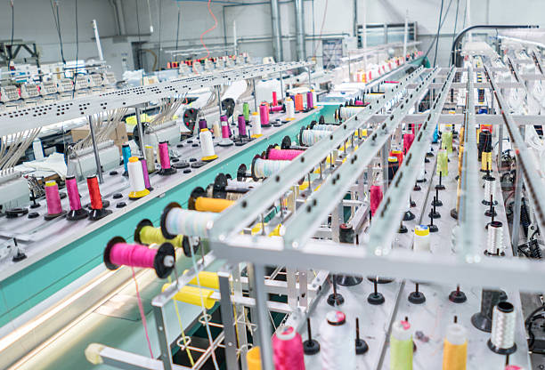 máquina de bordar en una fábrica de ropa - textile industry fotografías e imágenes de stock