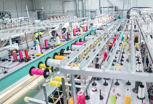 Working embroidery machine at a clothing factory - fashion industry concepts