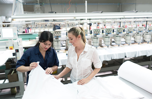 Women working at an embroidery factory and supervising the machines as they work