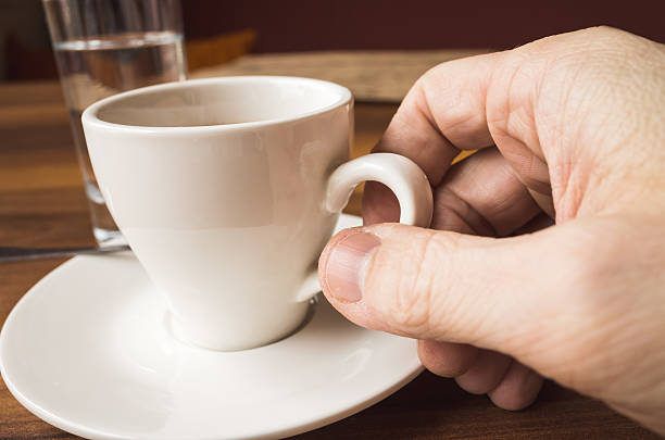istock Male hand holds white cup of espresso 585584082