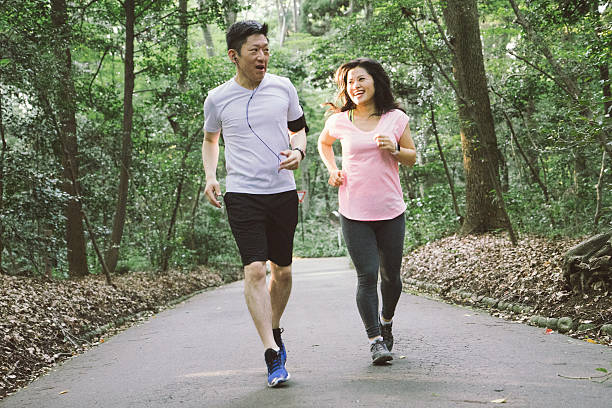 allegra coppia giapponese che corre all'aperto in un parco - running jogging asian ethnicity women foto e immagini stock